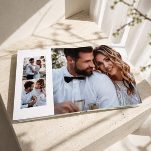 Álbum de casamento premium aberto com fotografias dos noivos distribuídas pelas páginas.