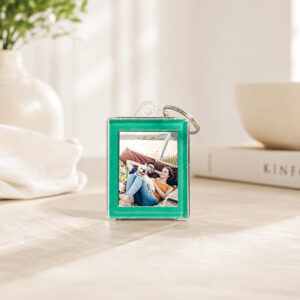 Porta-chaves verde personalizado com fotografia, apresentado sobre uma mesa num ambiente acolhedor.