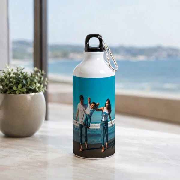 Garrafa personalizável com fotografia de família junto ao mar, apresentada num ambiente luminoso.