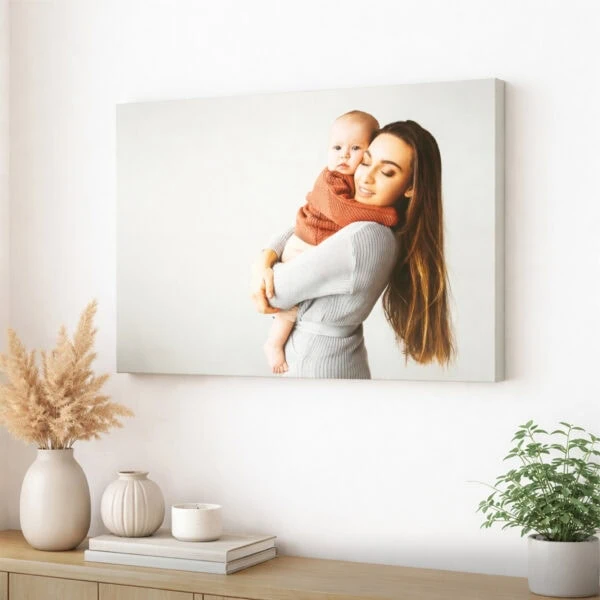 Tela personalizada com fotografia de mãe e bebé, aplicada numa parede de uma sala.