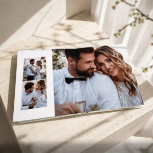 Álbum de casamento premium aberto com fotografias dos noivos distribuídas pelas páginas.